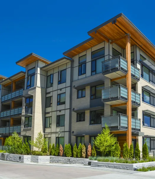 A shot of condo exteriors. White, modern building with a lot of wide windows.