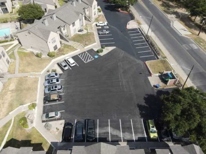An apartment complex gets a facelift with a new parking lot and striping.